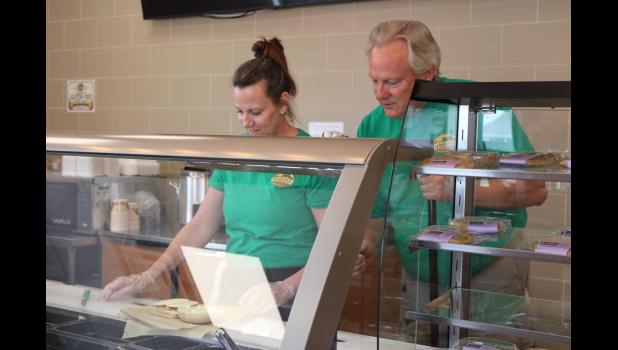 Harvest Sandwich Co. owners Amanda and Terry Molnar making a sandwich for a customer.