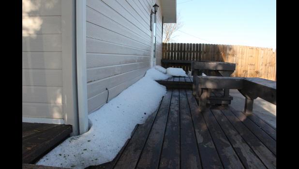 Banks of hail gathered along many structures and houses in the area, here a two foot drift along the house looked like Winter snow.