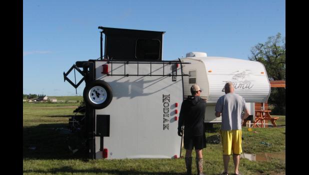 Joel Spry and Luke Weber discuss the damage to their two campers that were parked at the Lake Waggoner camp ground for the weekend. The other five campers reported no damage. Two campers on the ease side of the campground, from the Rapid City area, here for the weekend of fishing and golf, stayed with their campers through the storm.