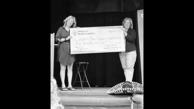 KCC Director, Heidi Coller accepts a gift from PAHF board member Jennifer Henrie. Courtesy Photo