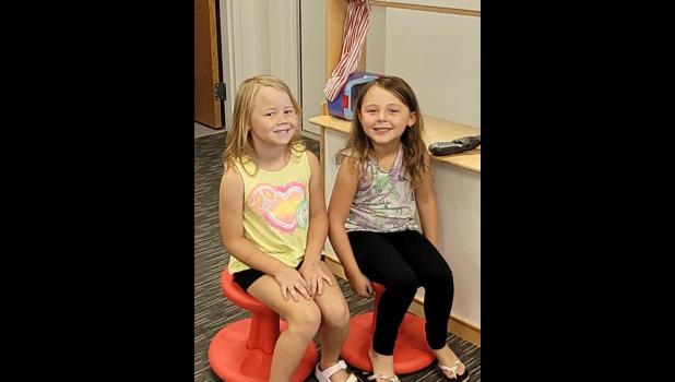 Krisee Veal and Jacey Hathaway spend a bit of time at the pup- pet show stage in Kindergarten.