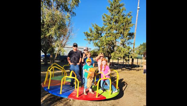 Fun on the newly painted merry-go-round, with the new light pole to the right. Courtesy Photo