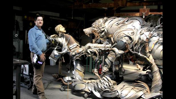 Lopez with the sculpture he is creating out of scrap metal.