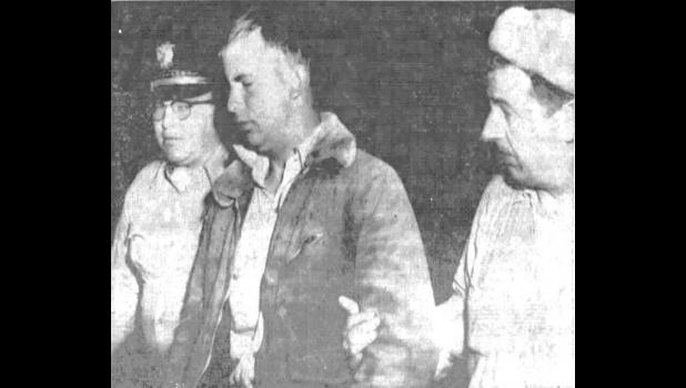 Husky Robert Mertz (center) is taken into custody May 13, 1958, as a suspect in the slaying of Mrs. Alex Stoeser and her daughter Linda at their ranch home northwest of Hayes, South Dakota. Officer at left is Police Chief Gay Moses of Philip, and at right is Mike Schofield, town marshal at Midland. Courtesy Photo