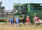 Family and friends discuss the day’s harvest plans at the Mike and Linda Gebes homestead, July 13.