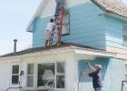 Some volunteers scraped off old paint, while others applied primer where needed, then painted the house yellow with brown trim.