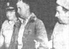 Husky Robert Mertz (center) is taken into custody May 13, 1958, as a suspect in the slaying of Mrs. Alex Stoeser and her daughter Linda at their ranch home northwest of Hayes, South Dakota. Officer at left is Police Chief Gay Moses of Philip, and at right is Mike Schofield, town marshal at Midland. Courtesy Photo